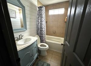 a bathroom with a sink and a toilet and a tub at 3BR Lakefront in Nashville with BBQ & Hot Tub in Old Hickory