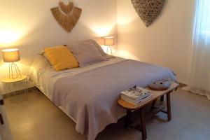 - une chambre avec un lit, une table et deux lampes dans l'établissement Appartement Les Hameaux de Pinarello, à Sainte-Lucie de Porto-Vecchio