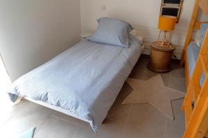 une petite chambre avec un lit avec une couette bleue dans l'établissement Appartement Les Hameaux de Pinarello, à Sainte-Lucie de Porto-Vecchio 2 autres photos