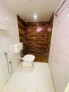 a bathroom with a toilet and a wooden wall at Jogi Lodge in Varanasi +27 photos