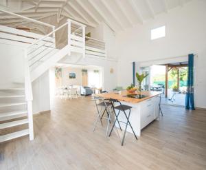 a living room with a kitchen and a loft at Villa Luciole Man'Néa in Sainte-Anne +32 photos