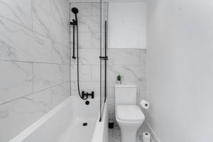 a bathroom with a shower and a toilet and a tub at Vacant Nests The Livingston Retreat Wi-fi in Uphall +22 photos