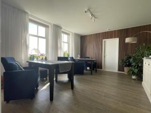 a dining room with a table and blue chairs at BenB Hoeve Weltevreden in De Westen