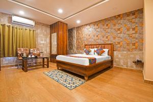 a bedroom with a bed and a brick wall at FabHotel Royal Lagoon - Near railway station gate number 1 in Bhubaneshwar