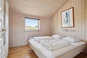 un letto bianco in una stanza con una finestra di Spacious Holiday Home Near Fjord & Beach a Ejsingholm