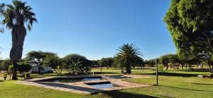 two pools in a park with palm trees at Hide Away Wedding,Conference & Function Venue in Bela-Bela