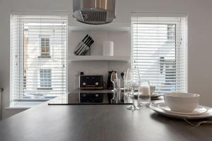 a kitchen with a wooden table with a bowl and plates on it at Exeter Escape - City Centre Apartment- Short Stays UK Ltd in Exeter