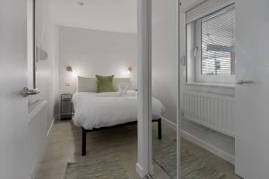 a white bedroom with a bed and a window at Exeter Escape - City Centre Apartment- Short Stays UK Ltd in Exeter