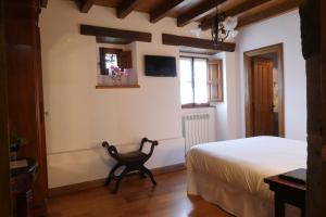 a bedroom with a bed and a tv on the wall at Hotel Palacio La Cajiga in Abándames