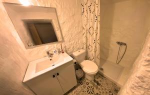 ein Badezimmer mit Waschbecken, Toilette und Spiegel in der Unterkunft Mi Candela in Valleseco + 15 Fotos