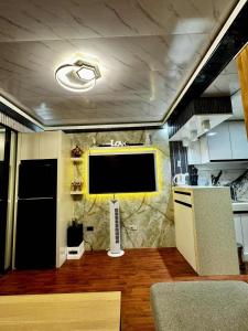 a kitchen with a large tv on a wall at Cozy Home in the heart of Mandaue City in Mandaue City
