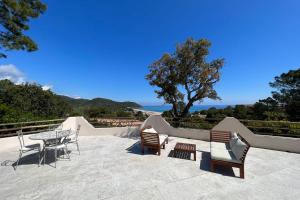 a patio with chairs and a table and a tree at Casa Vecchia Di Olmuccio in Sainte-Lucie de Porto-Vecchio