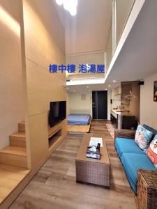 礁渓郷にあるcookies溫泉湯屋の青いソファとテレビのあるリビングルーム