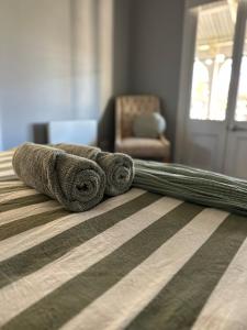 a pile of rolled up towels on a bed at Wattle Cottage in Cootamundra +6 photos