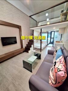 礁渓郷にあるcookies溫泉湯屋のソファとテレビのあるリビングルーム +2枚の写真