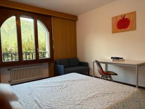 a bedroom with a bed and a desk and a chair at Capolago lake apartment in Mendrisio +8 photos