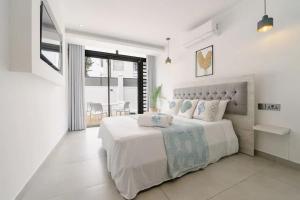 a white bedroom with a large bed and a window at Comfortable House in Trou-aux-Biches with Terrace in Trou aux Biches +24 photos