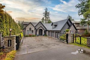 a large house with a gate and a driveway at Beach Breeze White Rock in White Rock