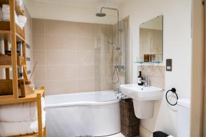 a bathroom with a tub and a sink and a shower at Torquay Beachside Hot Tub Stay in Stokeinteignhead +22 photos