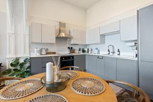 a kitchen with a wooden table with chairs at Torquay Beachside Hot Tub Stay in Stokeinteignhead