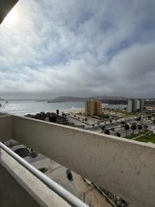 a view of a beach and the ocean from a balcony at La Serena, Vista al mar y piscina in Coquimbo