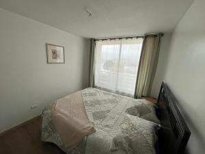 a bedroom with a bed in front of a window at La Serena, Vista al mar y piscina in Coquimbo +1 photo
