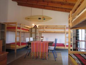 Una habitación con mesa, sillas y literas. en Da Silva Surfcamp, en Areia Branca
