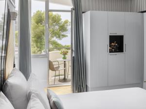 una camera da letto con un letto con camino e un balcone di The 1932 Hotel & Spa Cap d'Antibes - MGallery Collection a Juan-les-Pins