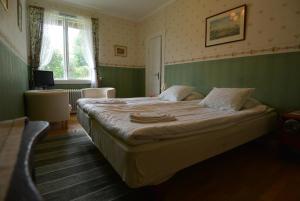 ein Schlafzimmer mit einem großen Bett in einem grünen Zimmer in der Unterkunft Pensionat Åsgården in Lyrestad