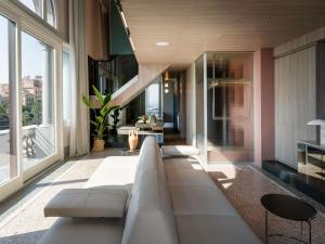 a living room with a couch and some windows at Palazzo Tirso MGallery Cagliari in Cagliari +162 photos