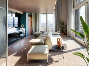 a living room with a long couch and a television at Palazzo Tirso MGallery Cagliari in Cagliari +161 photos