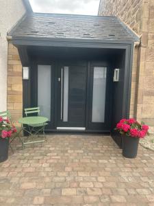 a black garage with a table and chairs and flowers at Spring Nook in Kelso