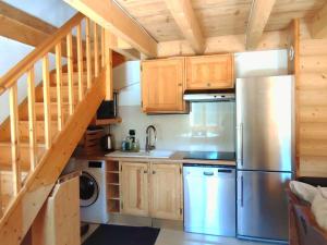a kitchen with wooden cabinets and a stainless steel refrigerator at Chalet haut de gamme à Isola 2000, proximité pistes, 6 couchages, Wi-Fi inclus - FR-1-292-193 in Isola