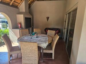 ein Esszimmer mit Tisch und Korbstühlen in der Unterkunft Family Home in Roodepoort