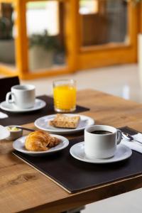 a table with plates of food and cups of coffee at Hotel Cordillera in El Bolsón +72 photos