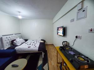 a small room with a bed and a television at Premier homes w free parking n lift in Rungiri
