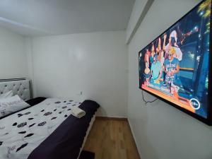 a bedroom with a large tv hanging on the wall at Premier homes w free parking n lift in Rungiri
