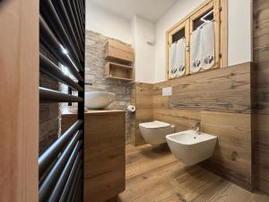 Un baño con dos lavabos y un inodoro. en Baita di noni, en Valdisotto 11 fotos más