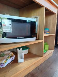 a microwave oven on a shelf in a kitchen at Bambú Cabaña in El Soberbio