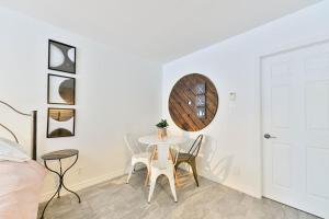 a white dining room with a table and chairs at Suite 2 - Val-Racine in Notre-Dame-Des-Bois