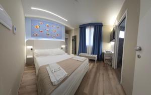 a bedroom with a bed and a blue painting on the wall at Vespucci Guest House in Pescara