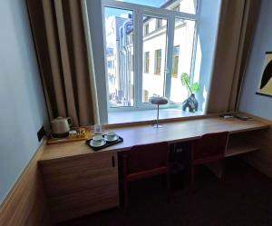 Cette chambre comprend un bureau en bois et une fenêtre. dans l'établissement Private Apartment in the Heart of Vilnius City Centre, à Vilnius