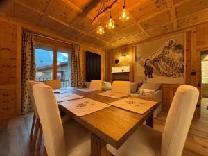 a dining room with a wooden table and chairs at Baita di noni in Valdisotto