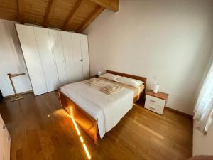 a bedroom with a large bed and a wooden floor at Casa Giarella in Isola della Scala +3 photos