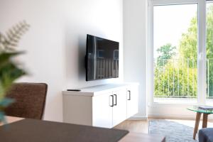 a living room with a television on a white cabinet at Apartment- Suite "ZIEGELHOF" in Niederdorla