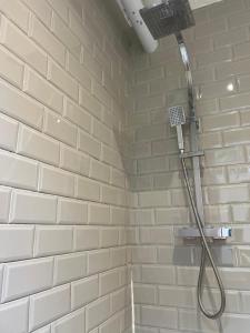 a shower in a bathroom with a white brick wall at Spacious 7-Bedroom Victorian House in Darlaston +51 photos