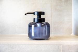 a glass soap dispenser sitting on a bathroom sink at Apartment- Suite "ZIEGELHOF" in Niederdorla +9 photos
