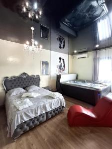 una camera da letto con un letto e un lampadario di La discrète romantique, appartement avec jacuzzi a Charavines Altre 6 foto