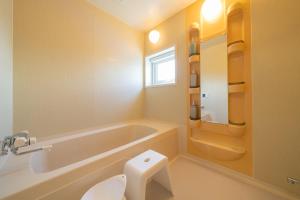 a bathroom with a tub and a toilet and a sink at Asahikawa House 2F in Asahikawa +33 photos