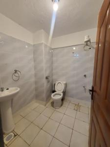 a bathroom with a toilet and a sink at Premier homes w free parking n lift in Rungiri +7 photos